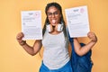 Young african american woman with braids showing failed and passed exam sticking tongue out happy with funny expression Royalty Free Stock Photo