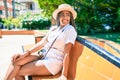 Young african american woman with braids smiling happy sitting on a bench outdoors on a sunny day of summer Royalty Free Stock Photo