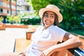 Young african american woman with braids smiling happy sitting on a bench outdoors on a sunny day of summer Royalty Free Stock Photo