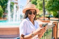 Young african american woman with braids smiling happy using smartphone outdoors on a sunny day of summer Royalty Free Stock Photo