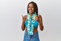 Young african american woman with braids wearing bikini and hawaiian lei pointing fingers to camera with happy and funny face Royalty Free Stock Photo