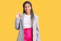 Young african american woman with braids wearing business clothes smiling positive doing ok sign with hand and fingers Royalty Free Stock Photo