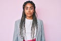 Young african american woman with braids wearing business jacket with serious expression on face