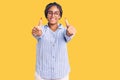 Young african american woman with braids wearing casual clothes and glasses approving doing positive gesture with hand, thumbs up Royalty Free Stock Photo