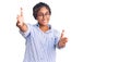 Young african american woman with braids wearing casual clothes and glasses looking at the camera smiling with open arms for hug Royalty Free Stock Photo