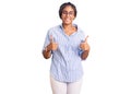 Young african american woman with braids wearing casual clothes and glasses success sign doing positive gesture with hand, thumbs Royalty Free Stock Photo