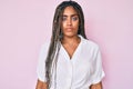 Young african american woman with braids wearing casual summer shirt with serious expression on face