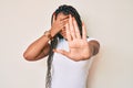 Young african american woman with braids wearing casual white tshirt covering eyes with hands and doing stop gesture with sad and Royalty Free Stock Photo