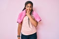 Young african american woman with braids wearing sportswear and towel looking confident at the camera smiling with crossed arms Royalty Free Stock Photo