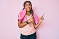 Young african american woman with braids wearing sportswear and towel smiling and looking at the camera pointing with two hands Royalty Free Stock Photo