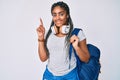 Young african american woman with braids wearing student backpack and headphones surprised with an idea or question pointing Royalty Free Stock Photo