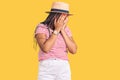 Young african american woman with braids wearing summer hat with sad expression covering face with hands while crying Royalty Free Stock Photo