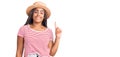 Young african american woman with braids wearing summer hat showing and pointing up with finger number one while smiling confident Royalty Free Stock Photo