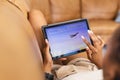 A young African American woman browses travel options on a tablet, booking a vacation online Royalty Free Stock Photo