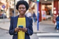 Young african american woman business executive using smartphone at street Royalty Free Stock Photo