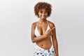Young african american woman with curly hair wearing bikini cheerful with a smile on face pointing with hand and finger up to the Royalty Free Stock Photo