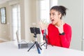 Young african american woman doing video call using smartphone camera and microphone crazy and mad shouting and yelling with Royalty Free Stock Photo