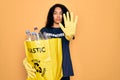 Young african american woman doing volunteering recycling holding bag with plastic bottles with open hand doing stop sign with Royalty Free Stock Photo