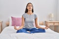 Young african american woman doing yoga exercise sitting on bed at bedroom Royalty Free Stock Photo