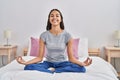 Young african american woman doing yoga exercise sitting on bed at bedroom Royalty Free Stock Photo