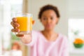 Young african american woman driking orange juice at home with a confident expression on smart face thinking serious Royalty Free Stock Photo