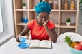 Young african american woman drinking coffee reading book at home Royalty Free Stock Photo