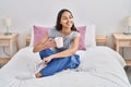 Young african american woman drinking cup of coffee sitting on bed at bedroom Royalty Free Stock Photo