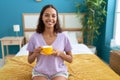 Young african american woman drinking cup of coffee sitting on bed at bedroom Royalty Free Stock Photo
