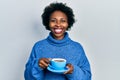 Young african american woman drinking a cup of coffee smiling with a happy and cool smile on face Royalty Free Stock Photo
