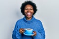 Young african american woman drinking a cup of coffee smiling and laughing hard out loud because funny crazy joke Royalty Free Stock Photo