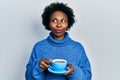 Young african american woman drinking a cup of coffee smiling looking to the side and staring away thinking Royalty Free Stock Photo