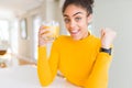 Young african american woman drinking a glass of fresh orange juice screaming proud and celebrating victory and success very Royalty Free Stock Photo