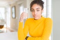 Young african american woman drinking a glass of fresh water with a confident expression on smart face thinking serious Royalty Free Stock Photo