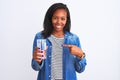 Young african american woman drinking a glass of fresh water over isolated background very happy pointing with hand and finger Royalty Free Stock Photo