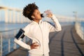 Young african american woman drinking water, having break during training outdoors Royalty Free Stock Photo