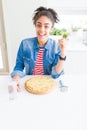 Young african american woman eating homemade cheese pizza very happy pointing with hand and finger to the side Royalty Free Stock Photo