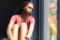 A young African American woman gazes out a window, deep in thought Royalty Free Stock Photo