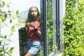 A young African American woman gazes thoughtfully through a window with copy space Royalty Free Stock Photo