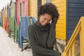 Young African American woman with hand in hair standing at beach hut Royalty Free Stock Photo