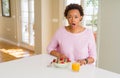 Young african american woman having healthy breakfast in the morning at home afraid and shocked with surprise expression, fear and Royalty Free Stock Photo