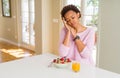 Young african american woman having healthy breakfast in the morning at home sleeping tired dreaming and posing with hands Royalty Free Stock Photo