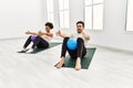 Young african american woman and hispanic man exercising at pilates room, stretching body and doing yoga pose, training strength Royalty Free Stock Photo