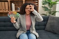 Young african american woman holding australian dollars at consultation office smiling happy doing ok sign with hand on eye Royalty Free Stock Photo