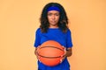 Young african american woman holding basketball ball skeptic and nervous, frowning upset because of problem