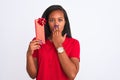 Young african american woman holding birthday present over isolated background cover mouth with hand shocked with shame for Royalty Free Stock Photo