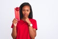 Young african american woman holding birthday present over isolated background serious face thinking about question, very confused Royalty Free Stock Photo