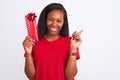 Young african american woman holding birthday present over isolated background very happy pointing with hand and finger to the Royalty Free Stock Photo