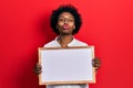 Young african american woman holding empty white chalkboard looking at the camera blowing a kiss being lovely and sexy Royalty Free Stock Photo