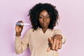 Young african american woman holding pregnancy test result pointing with finger to the camera and to you, confident gesture Royalty Free Stock Photo