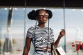 Young African American woman holding shopping bags while standing near shopping mall, Black Friday Royalty Free Stock Photo